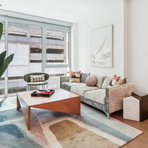 a living room with a couch, plant and a coffee table