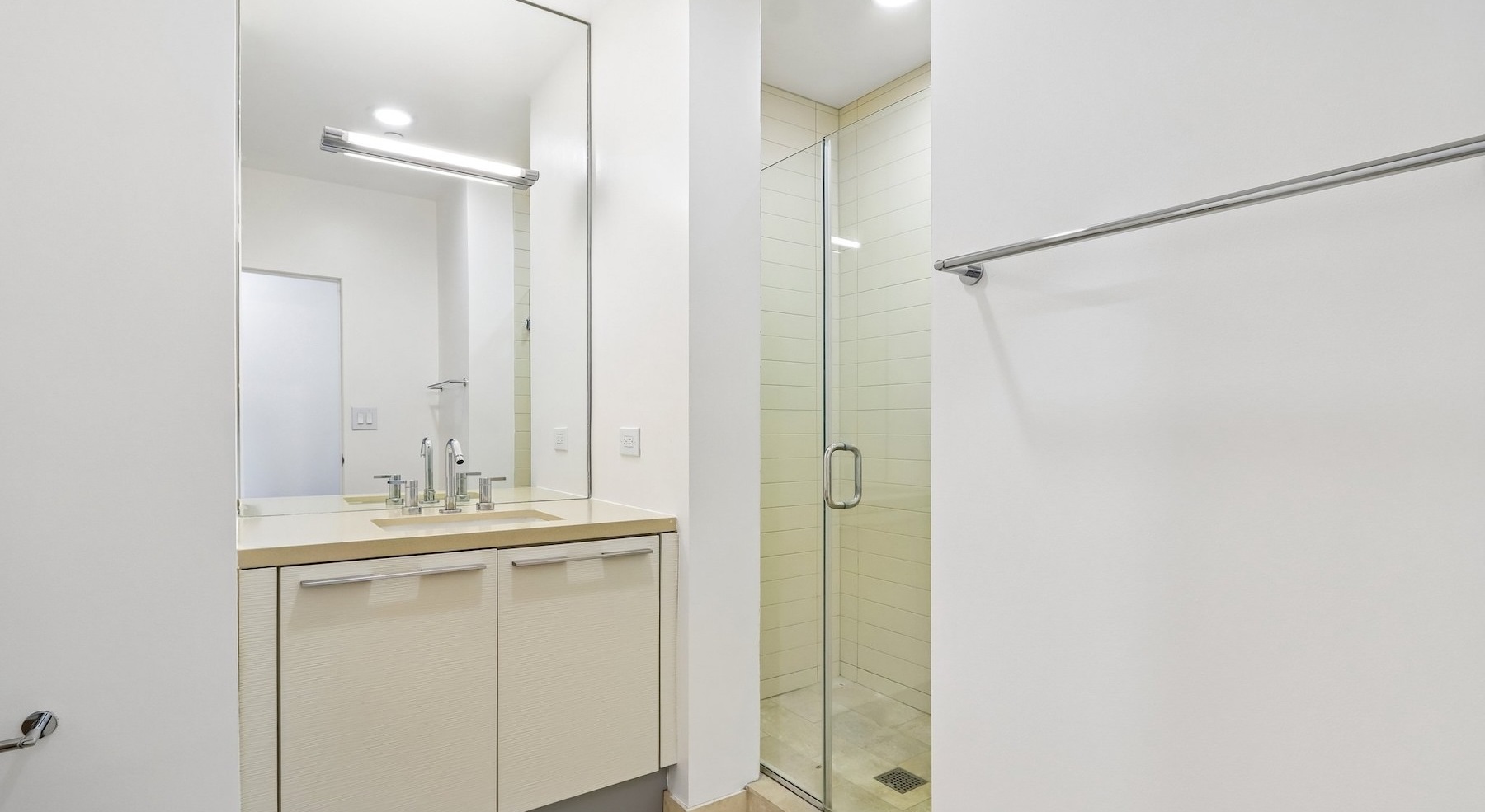 a bathroom with a sink, shower and mirror