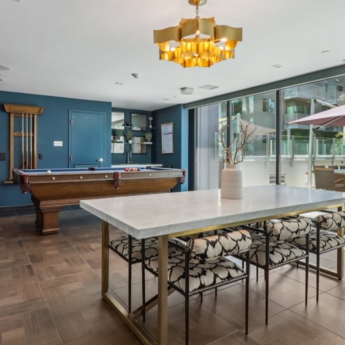a clubroom with a table, chairs and a pool table