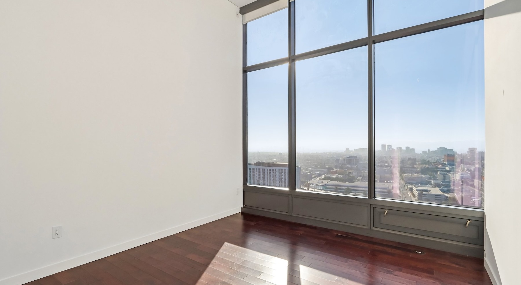 a living room with wood floors and large windows
