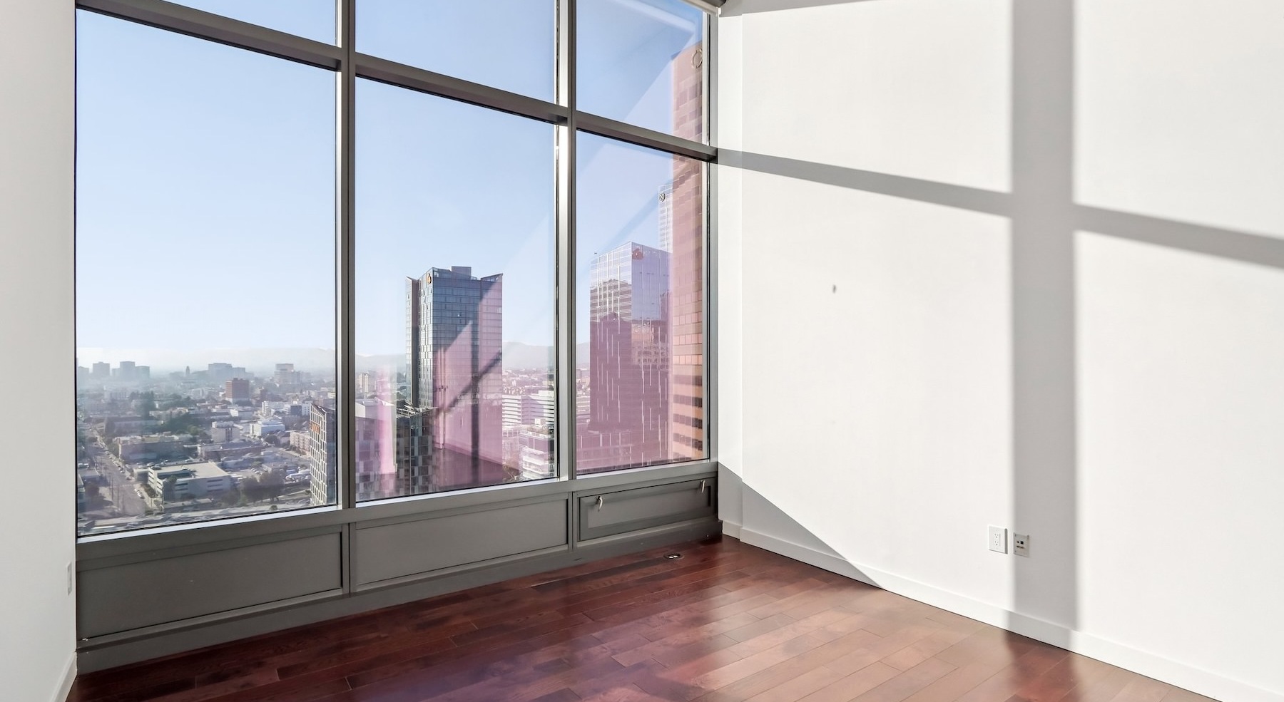 a living room with wood floors and large windows