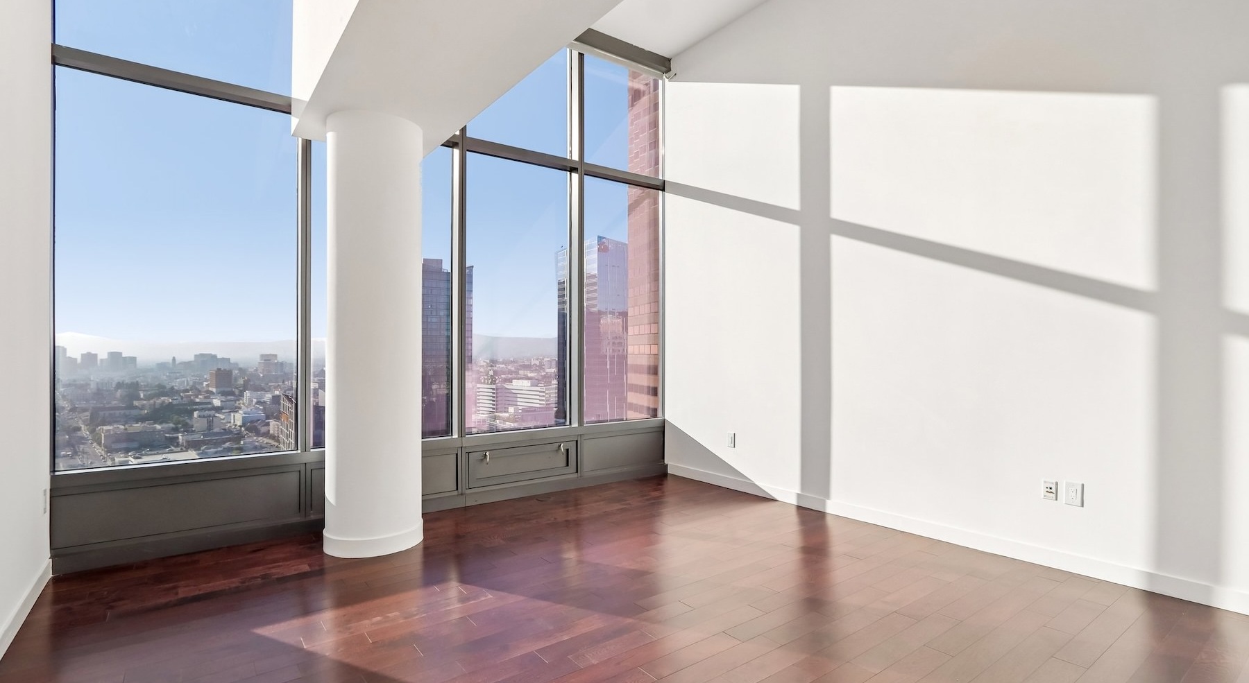 a living room with wood floors and large windows