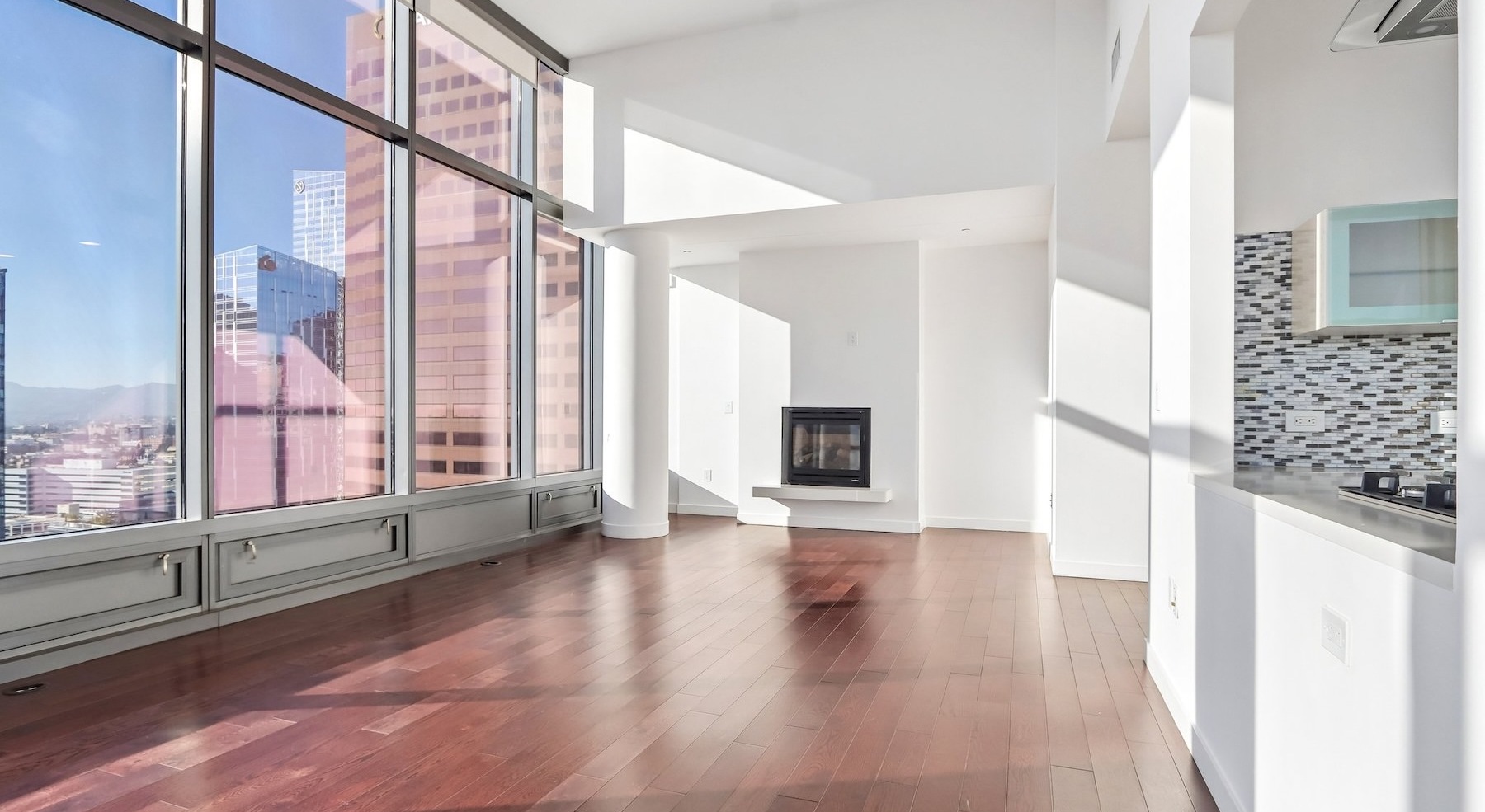a living room with wood floors and large windows