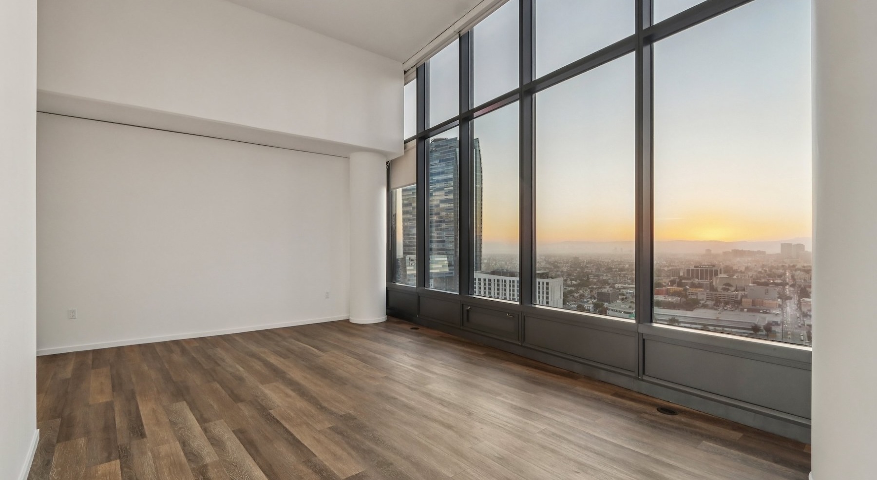 a living room with wood floors and large windows