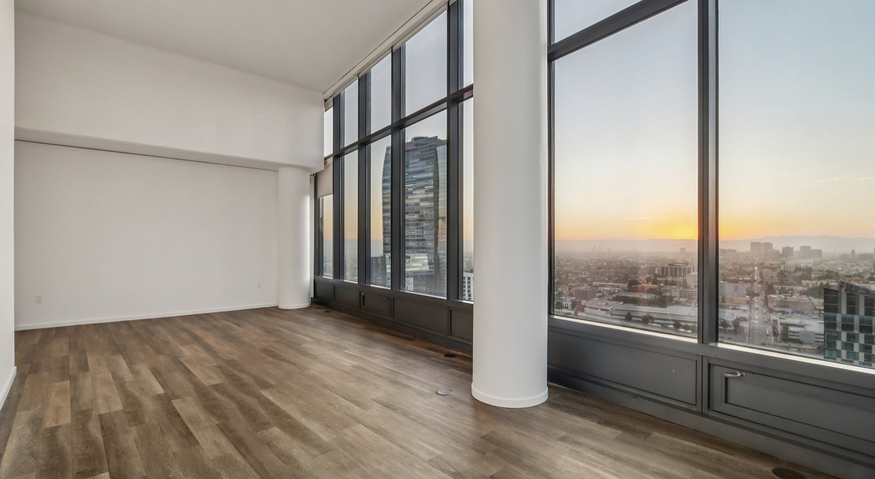 a living room with wood floors and large windows