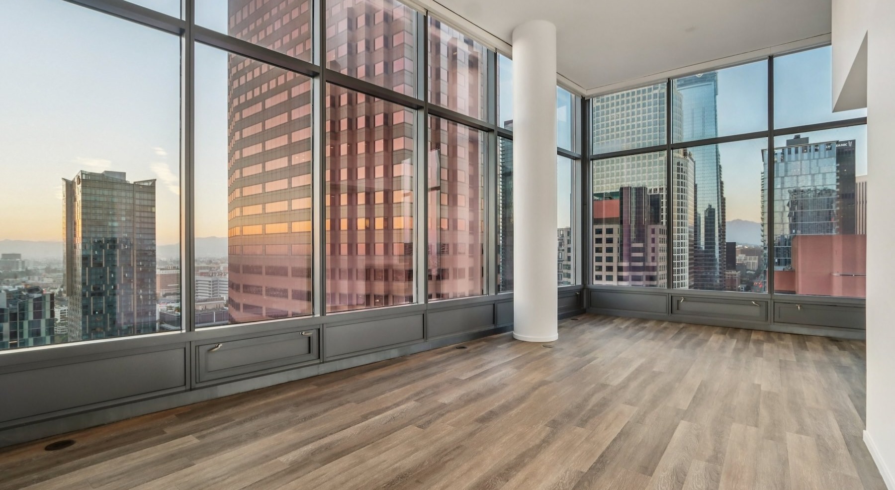 a living room with wood floors and large windows