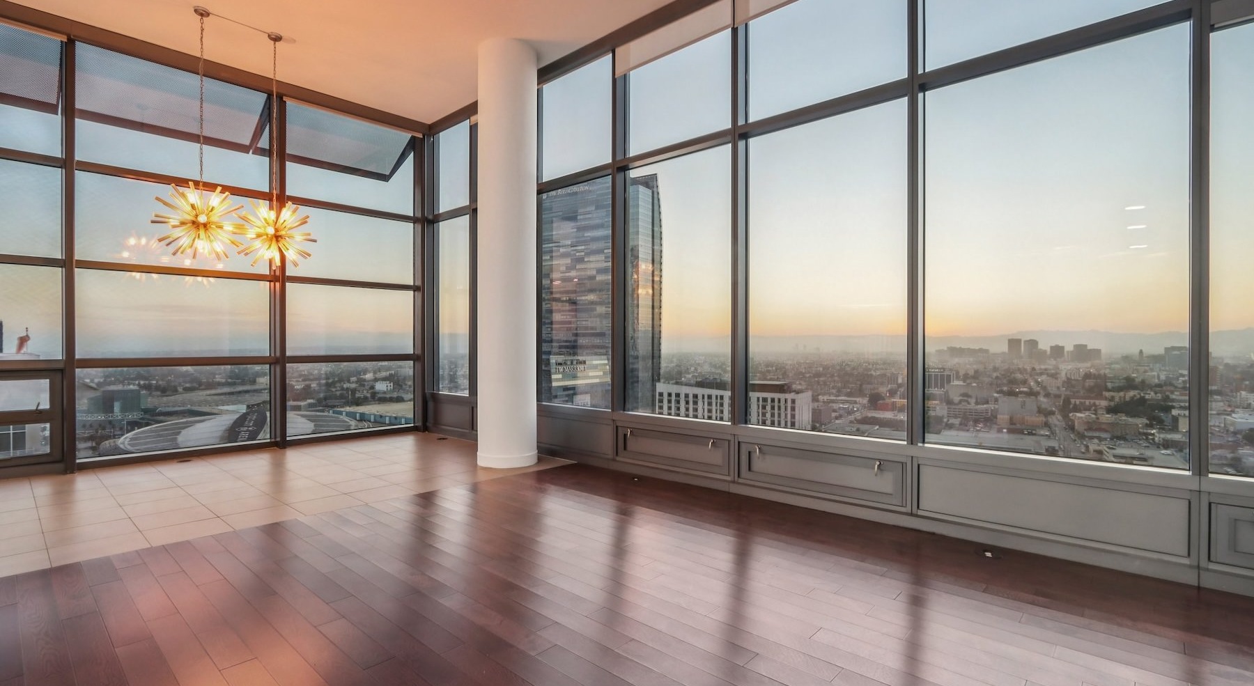 a living room with wood floors and large windows