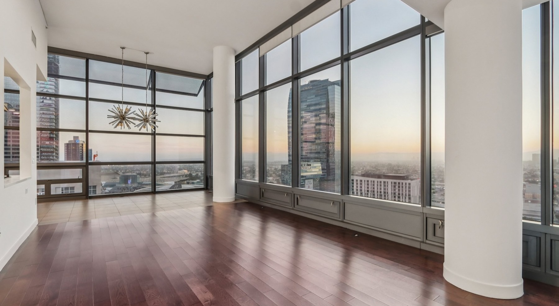 a living room with wood floors and large windows