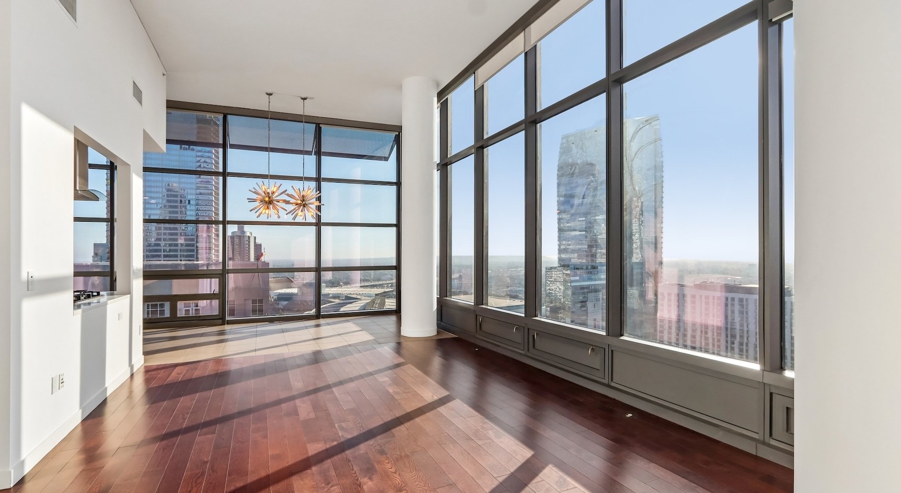 a living room with wood floors and large windows