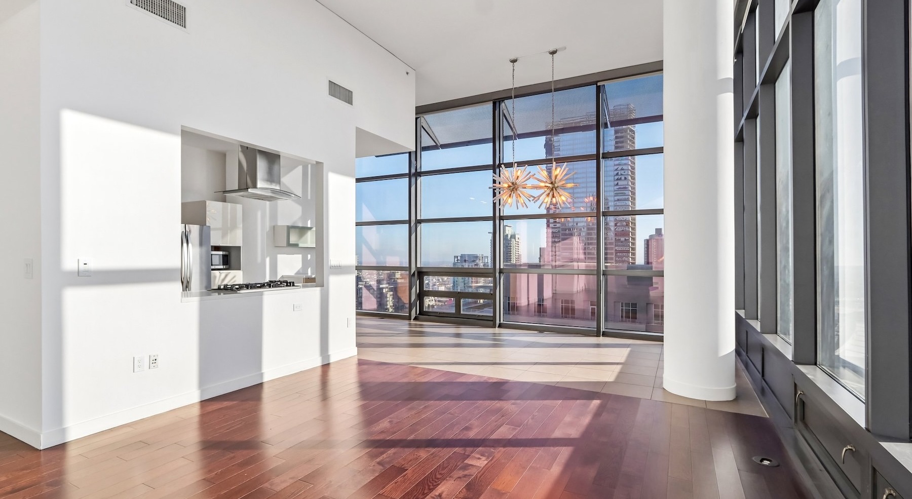 a living room with wood floors and large windows